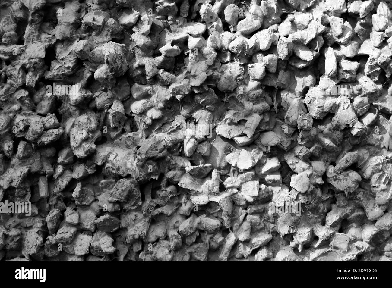 Graue Textur mit Stein, Kies und Zement in Licht und Schatten Stockfoto