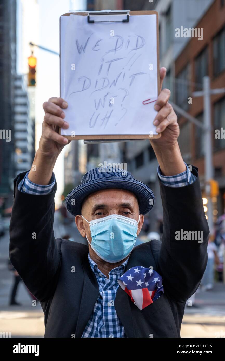 New York, USA. November 2020. Die Menschen tragen Gesichtsmasken, während sie auf dem New Yorker Times Square feiern, nachdem die Nachricht ausbrach, dass der ehemalige Vizepräsident Joe Biden die US-Präsidentschaftswahlen gewonnen hat. Biden besiegte Präsident Donald Trump, um zum 46. Präsidenten der Vereinigten Staaten zu werden, und Kamala Harris wird die erste weibliche Vizepräsidentin sein. Kredit: Enrique Shore/Alamy Live Nachrichten Stockfoto