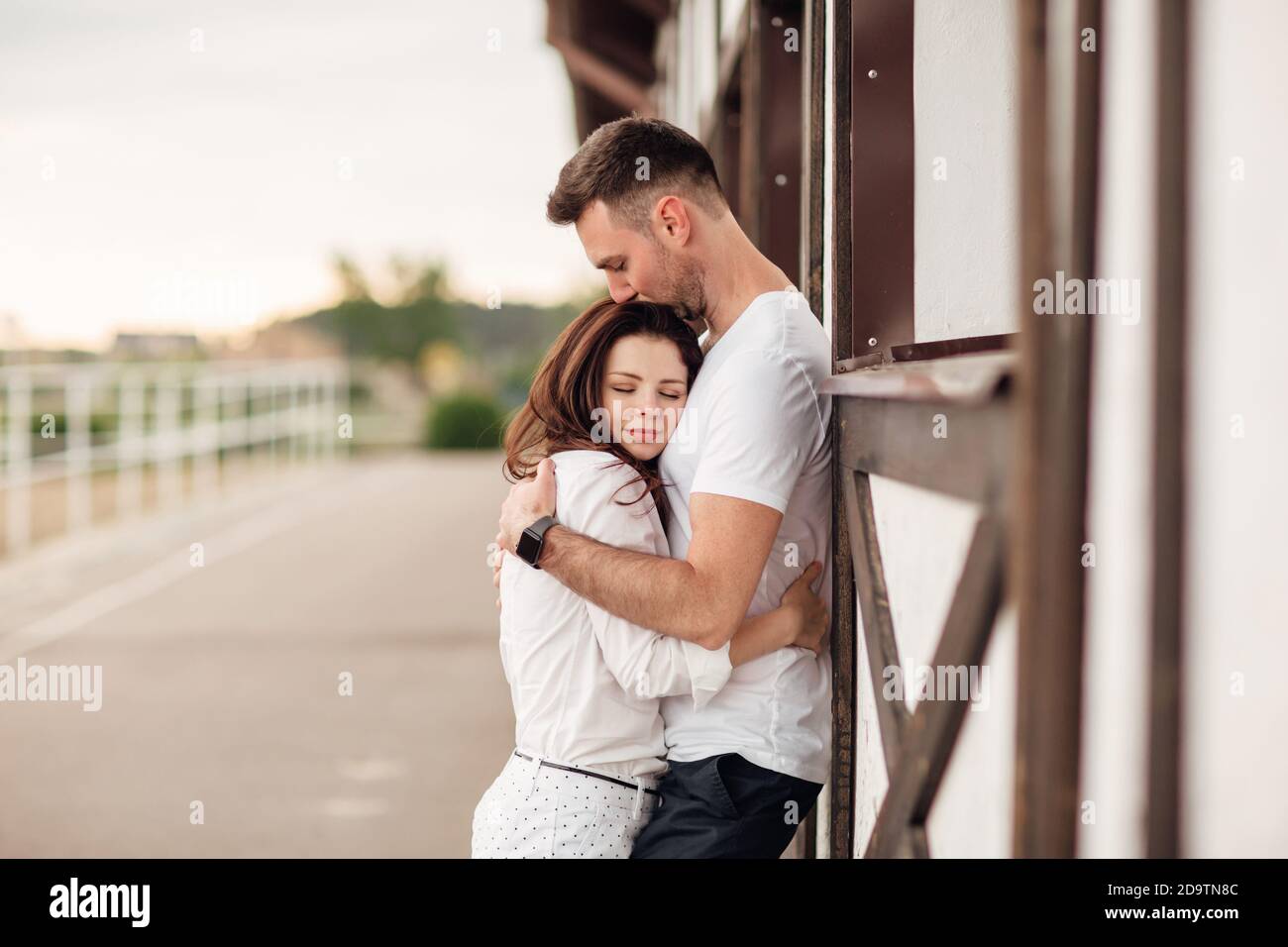 Glückliche junge Mann und Frau mit Spaß im Freien an einem warmen Sommertag. Paar umarmt in der Nähe Pferd rancho Stockfoto