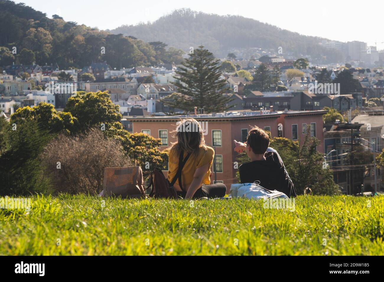 San Francisco, Kalifornien, USA - MÄRZ 15 2019: Leute, die ein Picknick im Alamo Square Park an einem sonnigen Tag mit blauem Himmel machen Stockfoto