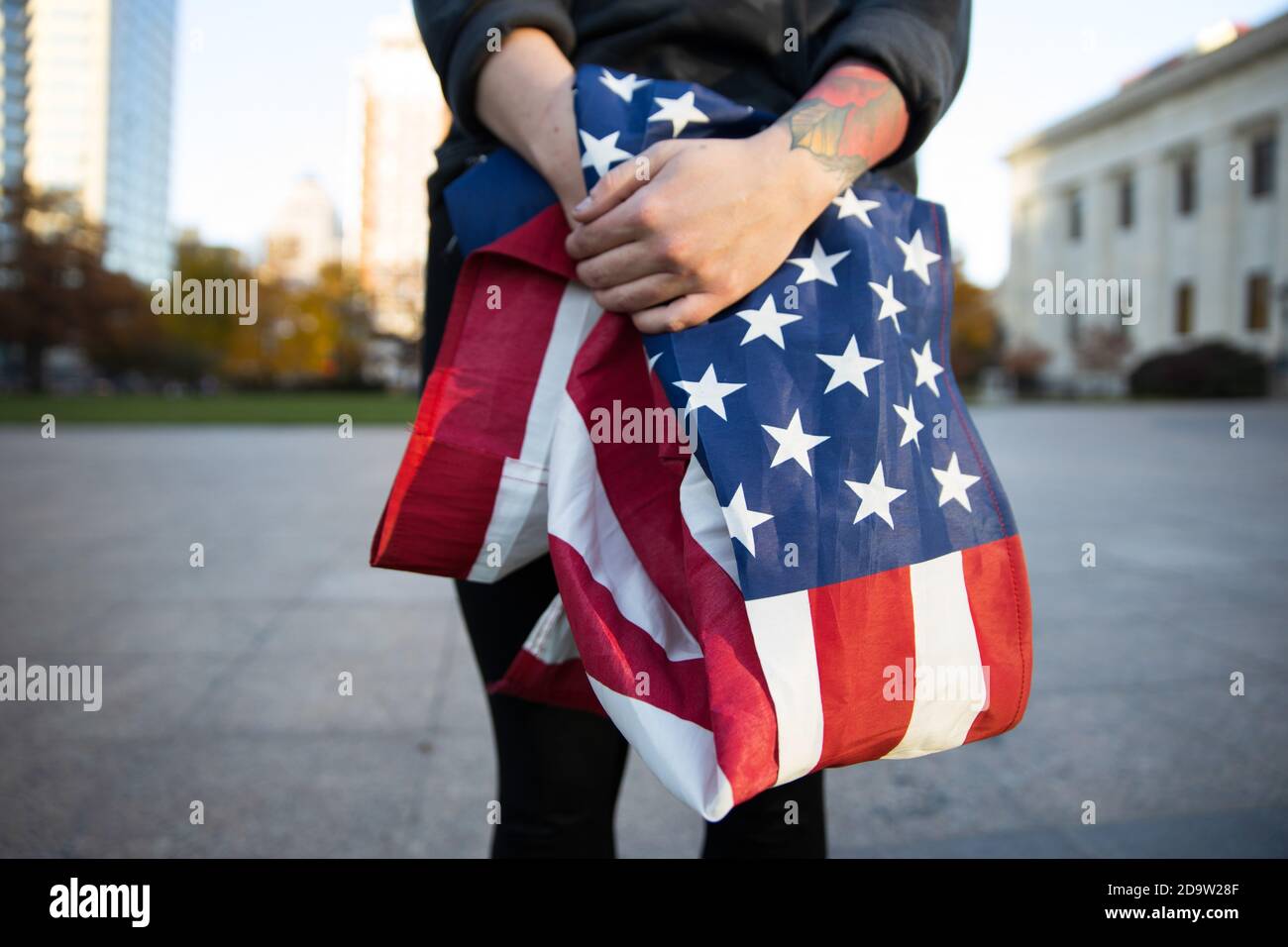 Ein Mann hält eine amerikanische Flagge vor dem Ohio State House, um Biden zu erniegen, nachdem sein Sieg als 46. Präsident der Vereinigten Staaten angekündigt wurde. Stockfoto