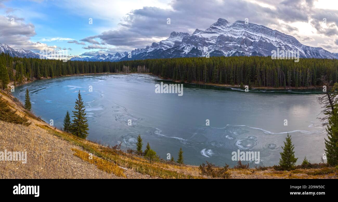 Der Johnson Lake Rundle Mountain Peaks Range Banff National Park Ist Mit Gefrorenem Eis Bedeckt. Malerische Springtime Alberta Foothills, Wandern Sie In Den Kanadischen Rocky Mountains Stockfoto