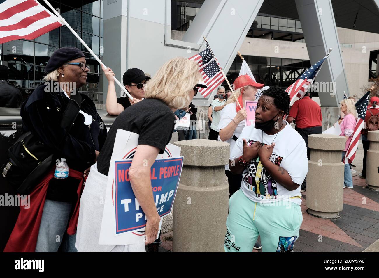 Atlanta, Georgia, USA. November 2020. Zwei Demonstranten führen eine politische Diskussion außerhalb der State Farm Arena in Atlanta, wo sich eine Gruppe von Trump-Anhängern am selben Tag versammelt hat, an dem der ehemalige Vizepräsident Joe Biden als Sieger der US-Präsidentschaftswahlen 2020 bekannt gegeben wurde. Kredit: John Arthur Brown/ZUMA Wire/Alamy Live Nachrichten Stockfoto