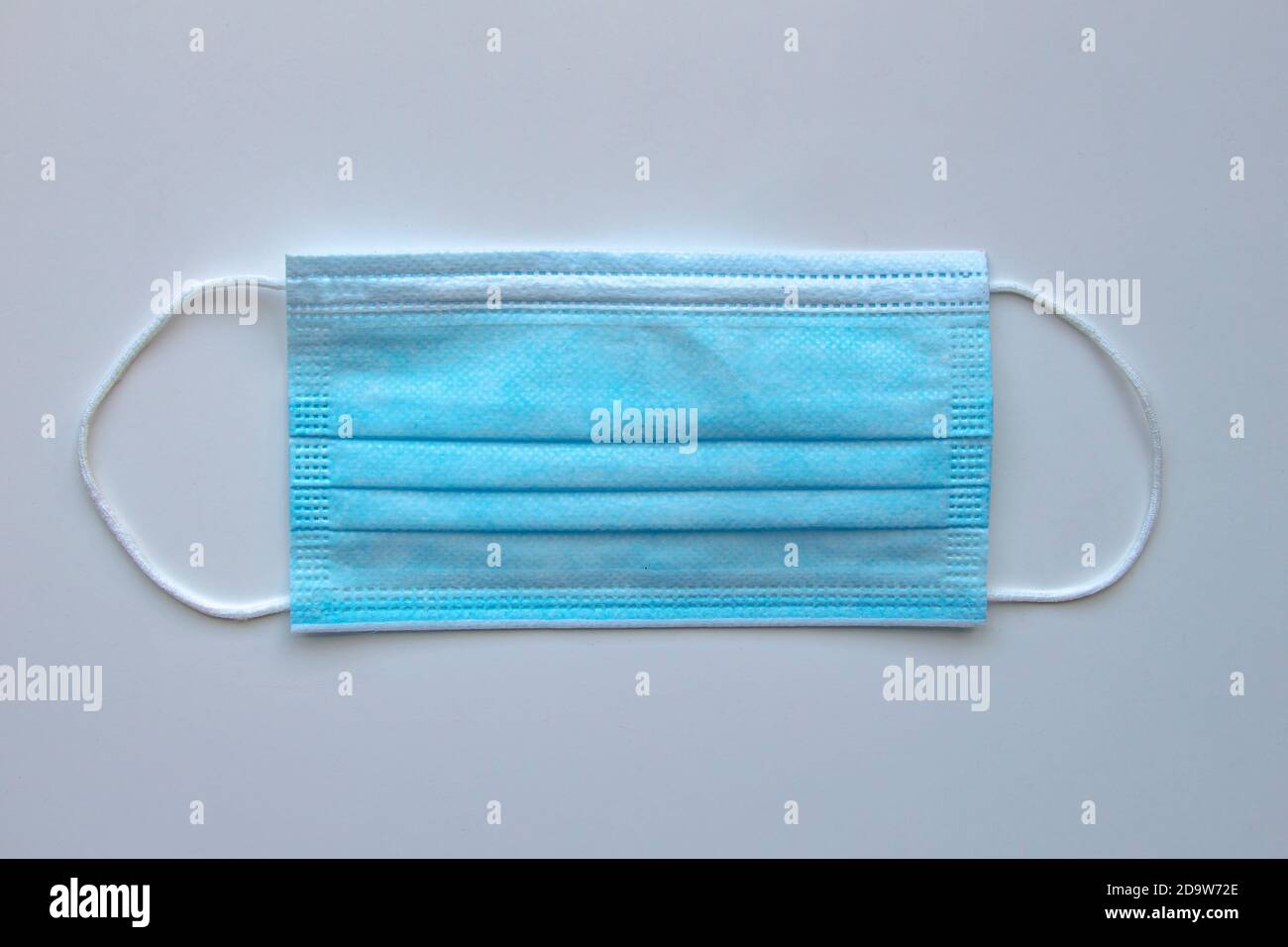 Eine medizinische Gesichtsmaske auf grauem Hintergrund Stockfoto