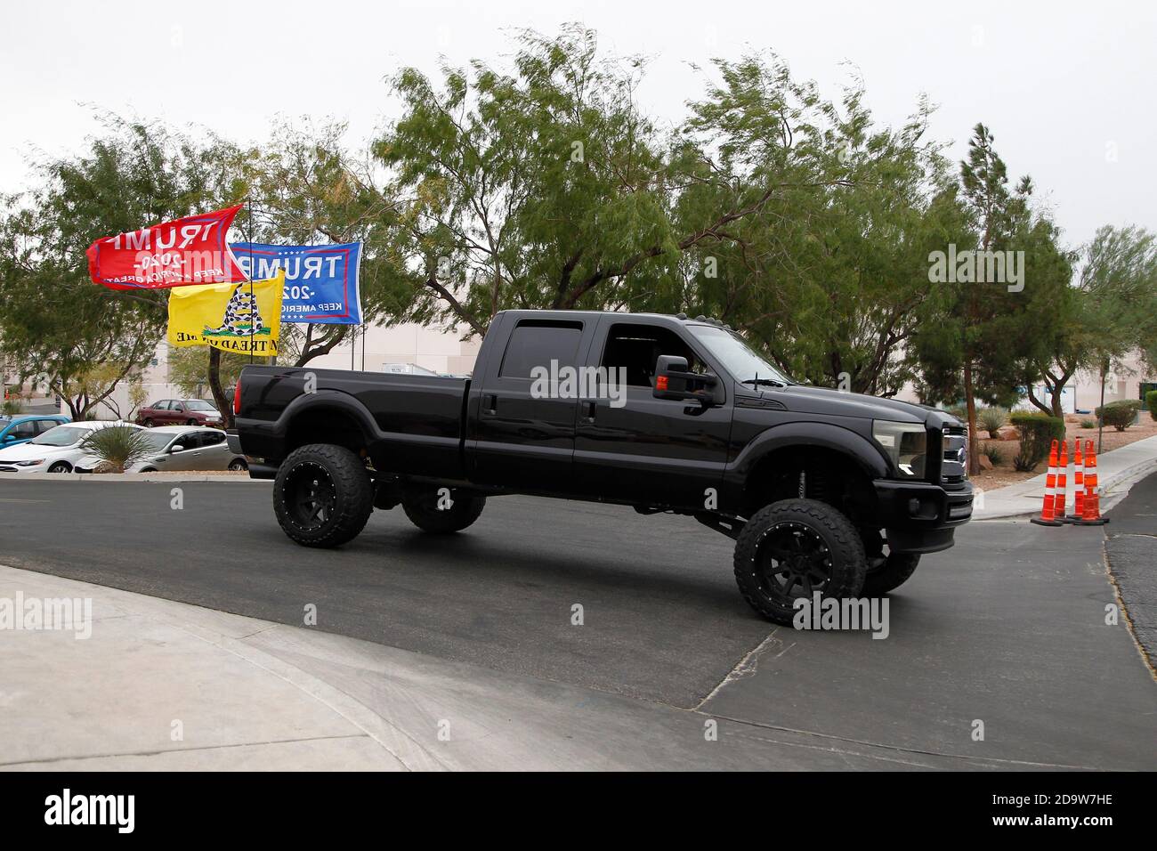 Las Vegas, Usa. November 2020. Ein schwarzer LKW mit Trump-Flaggen fährt am Samstag, den 7. November 2020, durch das Clark County Election Department Building in North Las Vegas. Foto von James Atoa/UPI Kredit: UPI/Alamy Live Nachrichten Stockfoto