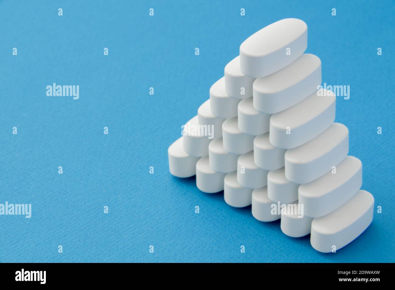 Viele weiße Tabletten Pillen auf blauem Hintergrund mit Kopieplatz Stockfoto