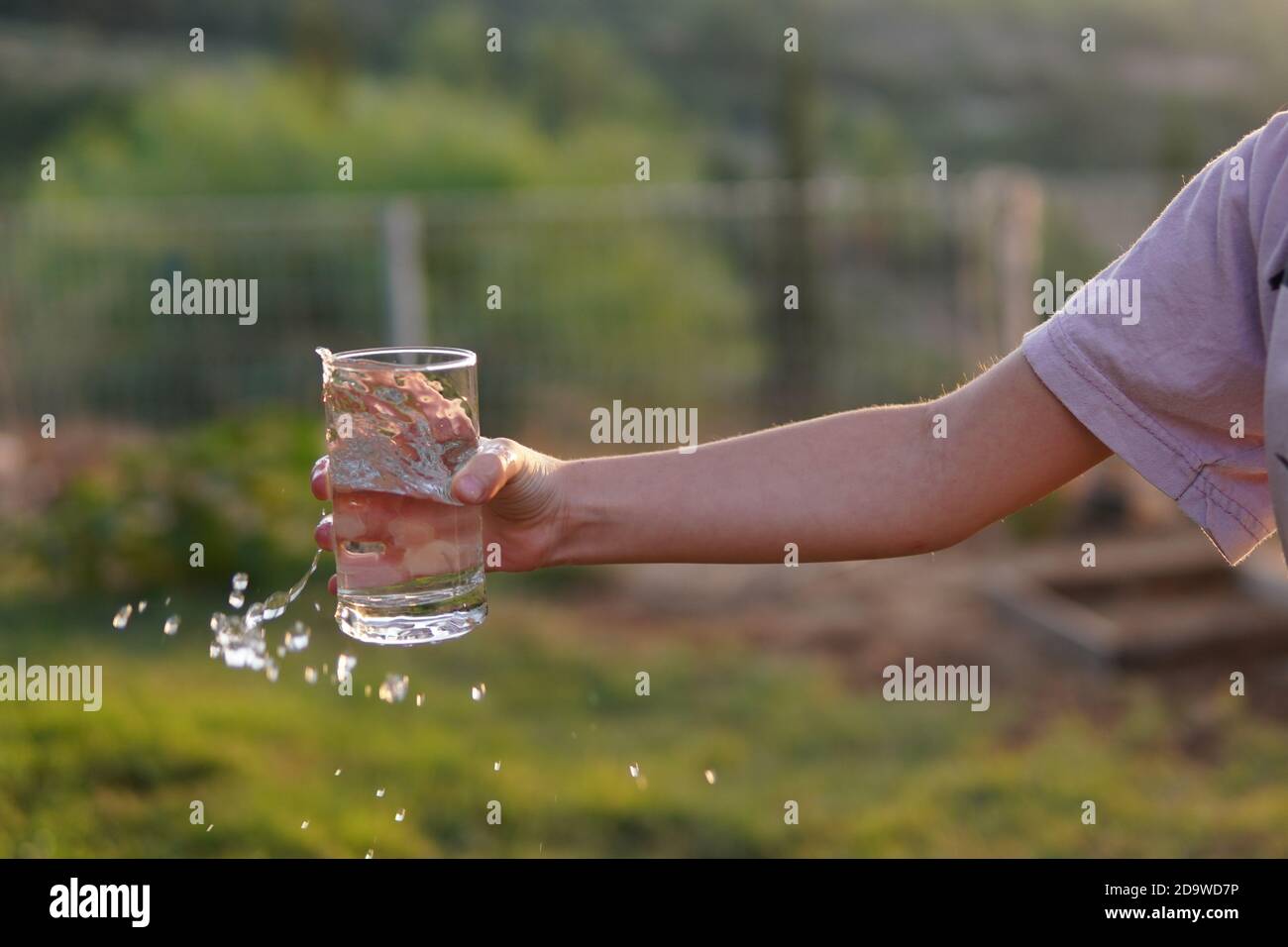 Mädchen verschüttet Wasser aus Glas Stockfoto