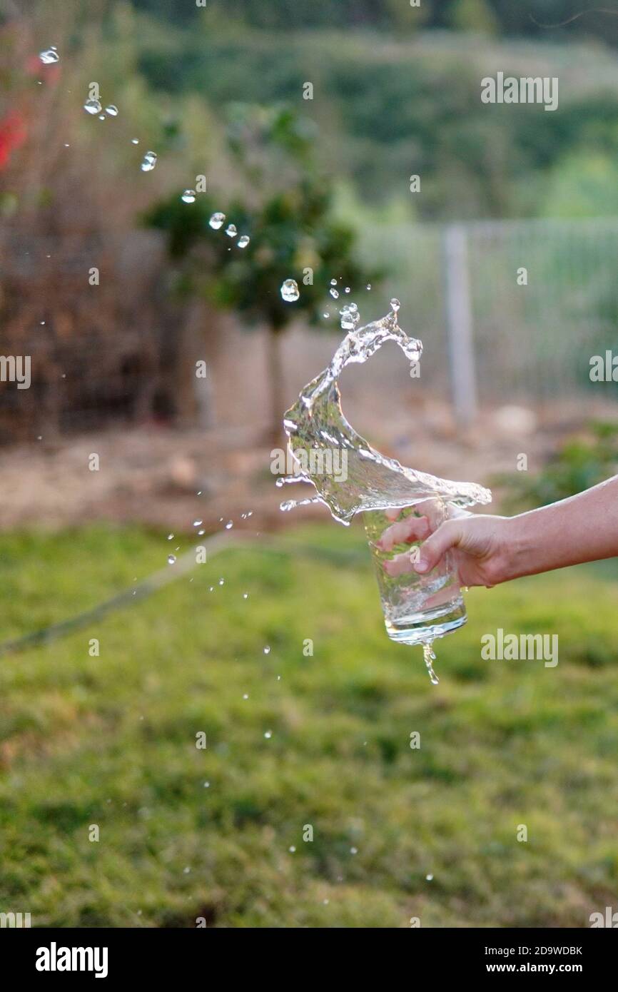 Mädchen verschüttet Wasser aus Glas Stockfoto
