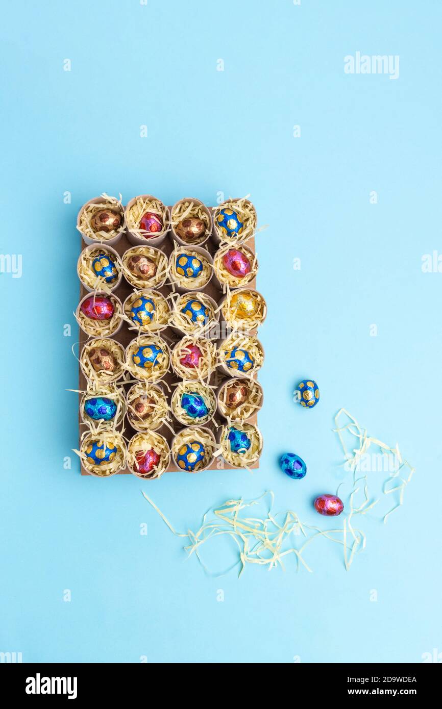 Toilettenrolle Adventskalender Handwerk, DIY, Schritt 3, Füllen mit Süßigkeiten, Draufsicht, blauer Hintergrund, Aktivität für Kinder Tutorial Stockfoto