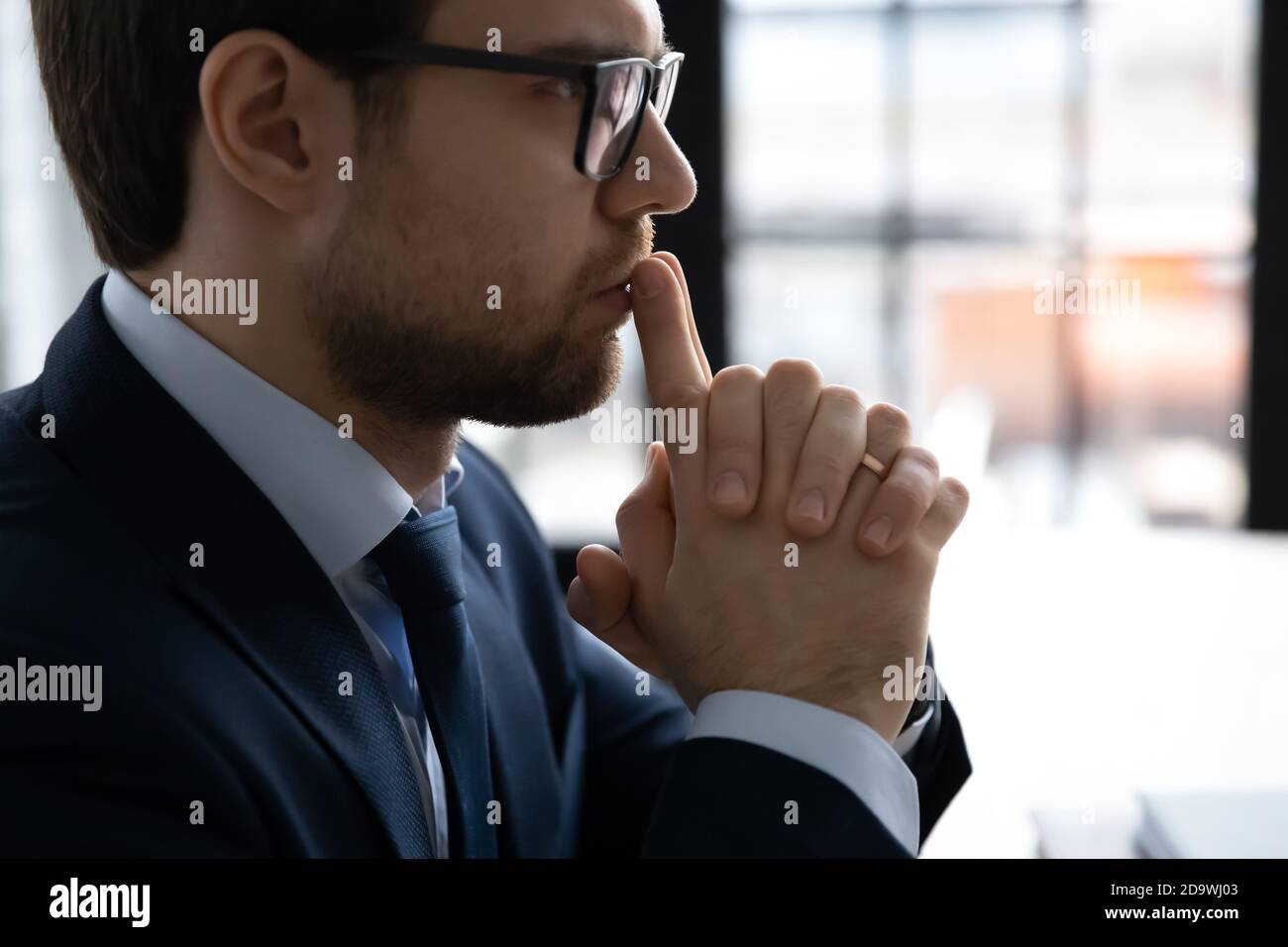 30er Geschäftsmann in formellen Anzug denken an Problemlösung. Stockfoto
