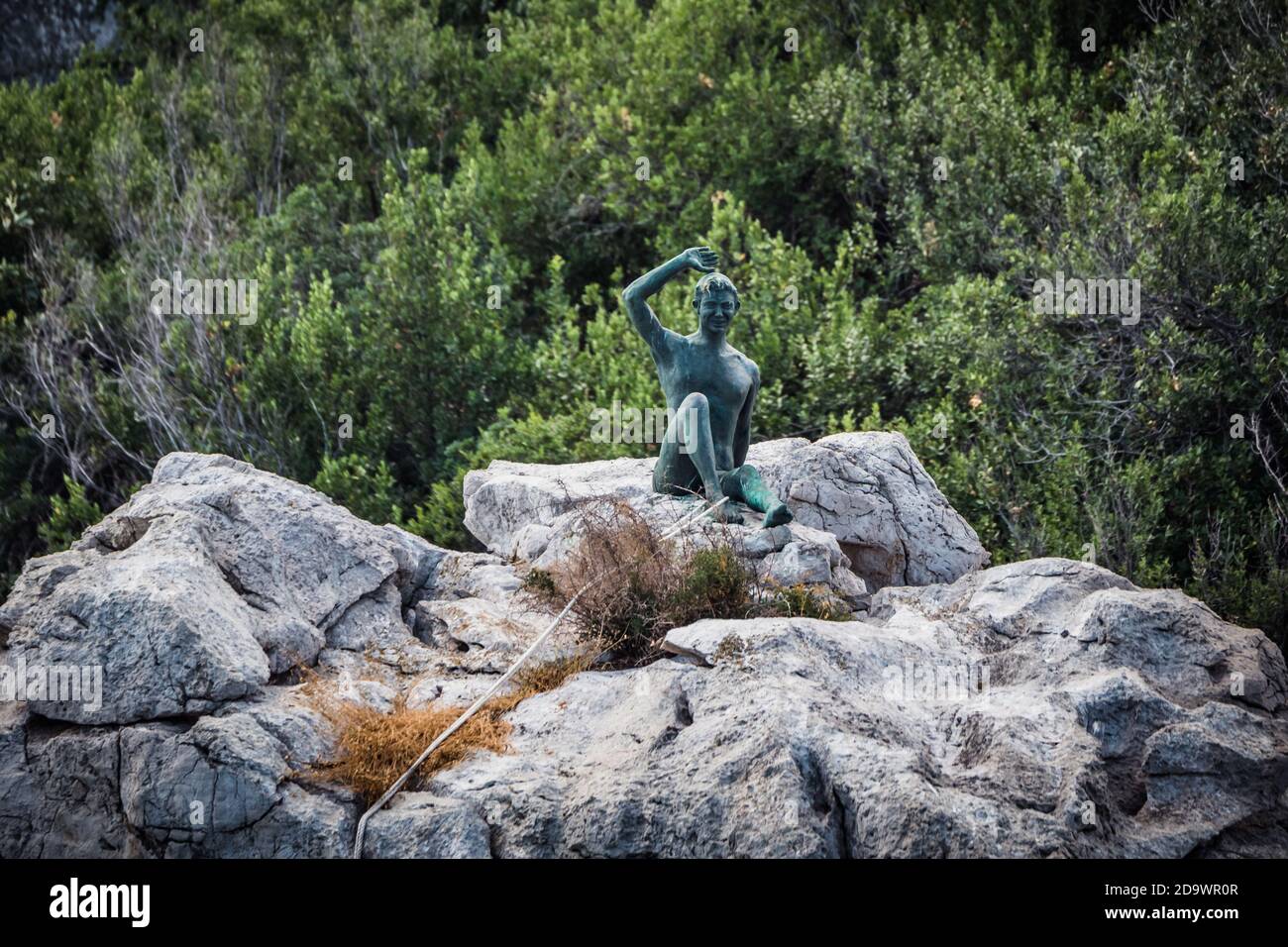 Capri, Italien - August 27 2020: Gennarino Scugnizzo Statue eines jungen Jungen Gruß an die Besucher auf einem Felsen Stockfoto