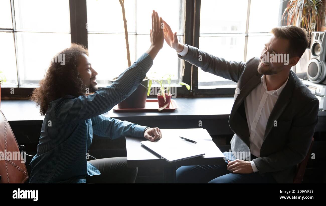 Multiethnische Millennial Männer besten Freunde vereinen Hände in High Five Stockfoto