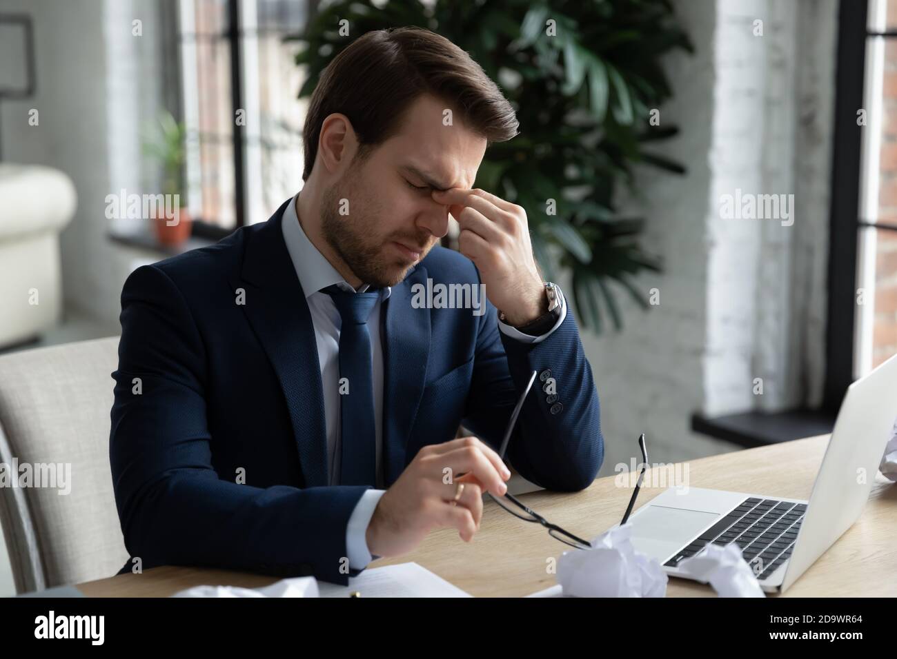 Unglücklich junge müde Geschäftsmann in formellen Anzug Ausziehen Brille. Stockfoto