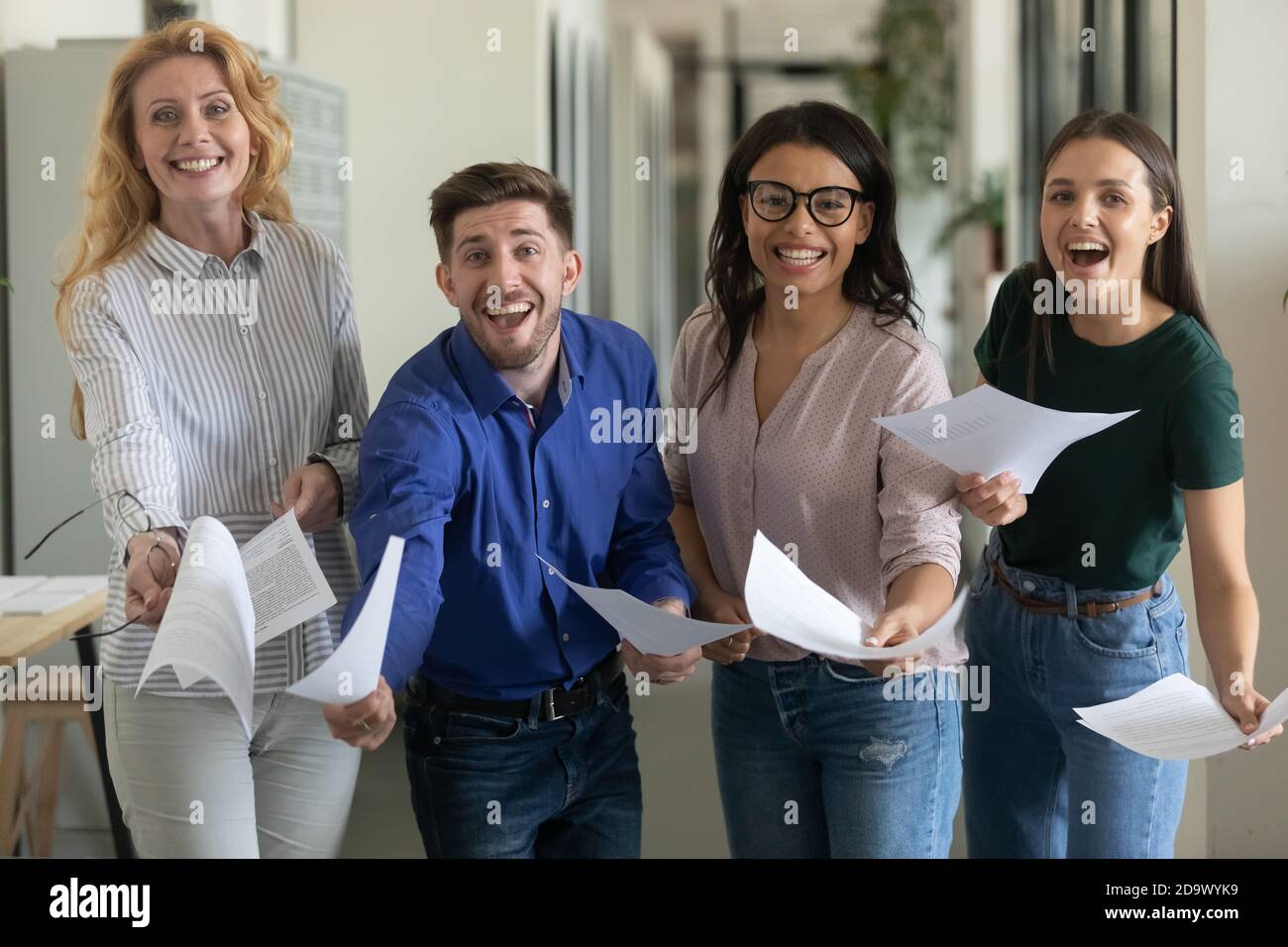 Gruppenportrait des lachenden aufgeregt Geschäftsteams zeigt bestätigten Vertrag Stockfoto