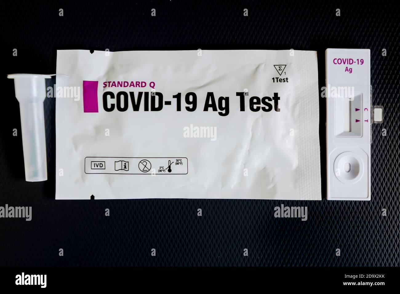 Ein schneller Antigentest für Covid-19 Coronavirus-Ansteckungskontrolle und Seine Verpackung mit speziellem Verdünnungsmittel auf schwarzem Hintergrund Stockfoto