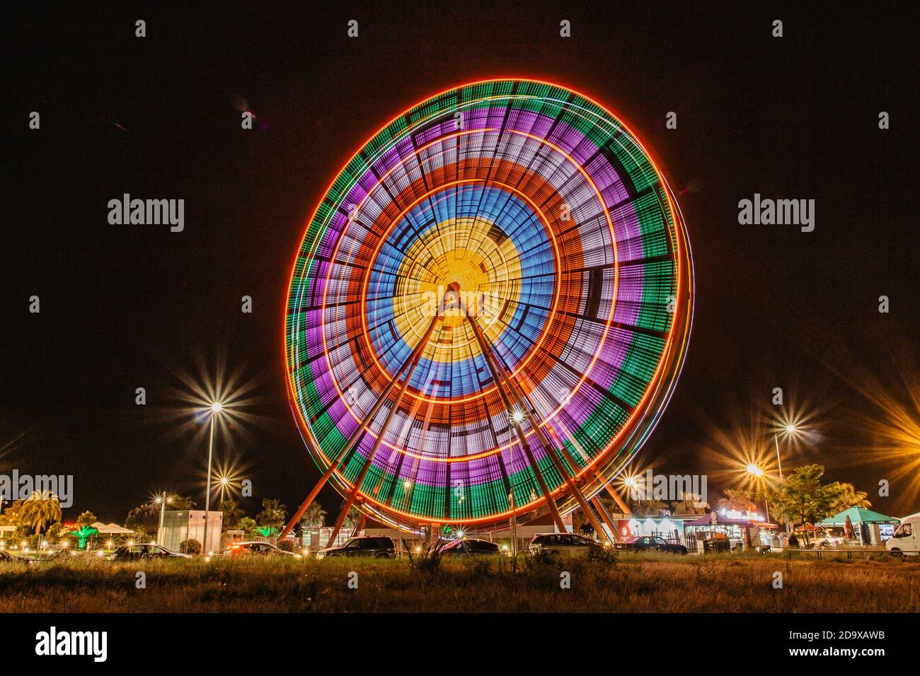 Großes Rad an der Küste von Batumi, Georgia. Riesenrad und Achterbahn in Bewegung. Lange Exposition Stadtlichter.Touristenziel.Reisen Stockfoto