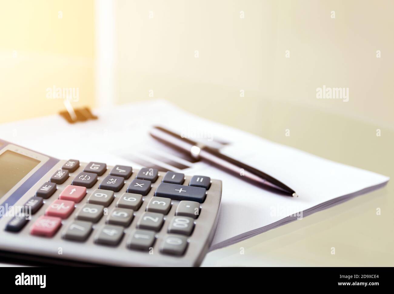 Soft Focus von einem Stift und Rechner mit Papierkram auf dem Glastisch; Soft Focus Filter Hintergrund für Business-Konzept. Stockfoto