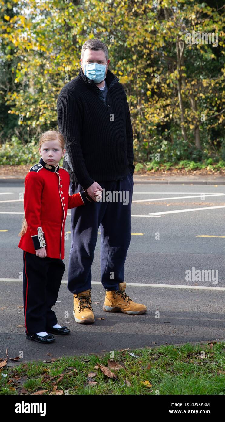 Biggin Hill,UK,8. November 2020,Trotz Lockdown besuchen Menschen einen Gedenkdienst in Biggin Hill Kent.EIN Kind in roter Soldatenuniform steht mit ihrem Vater. Kredit: Keith Larby/Alamy Live Nachrichten Stockfoto