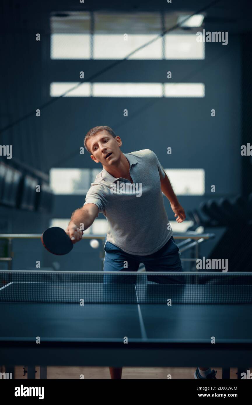 Mann trifft den Ball am Netz, Tischtennis Stockfoto