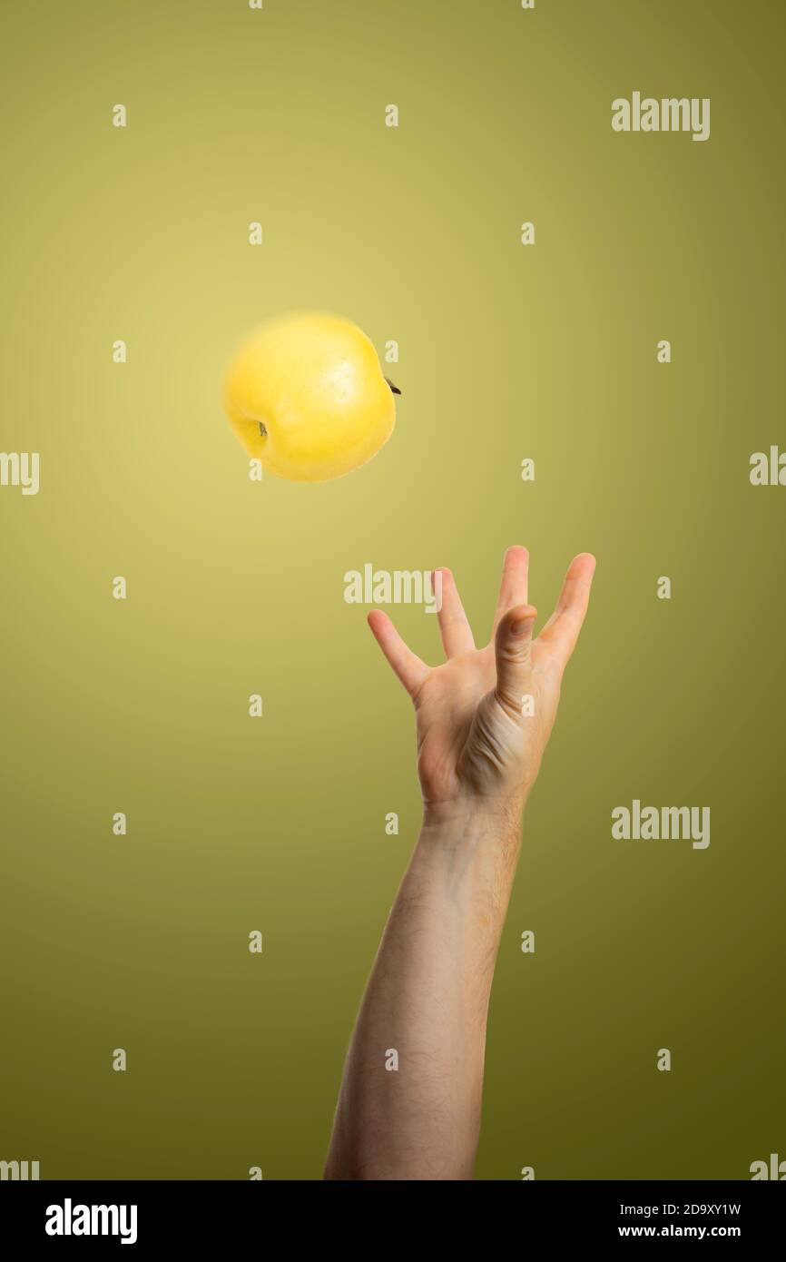 Hand fangen einen Apfel auf bunten Hintergrund, Studio-Foto Stockfoto