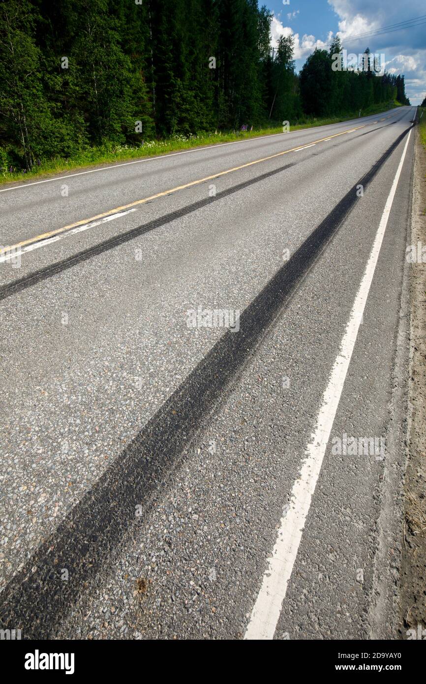 Sehr lange Gleitspuren auf Asphalt auf der Autobahn nach starkem Bremsen im Sommer in Finnland Stockfoto