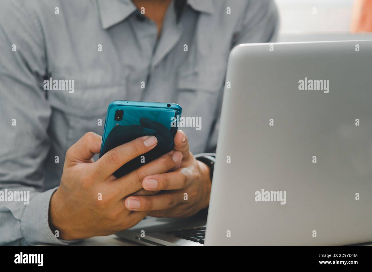 Mann hält ein Telefon, um Informationen, Web, Anwendungen und soziale Netzwerk und Computer Notebook zu sehen. Stockfoto