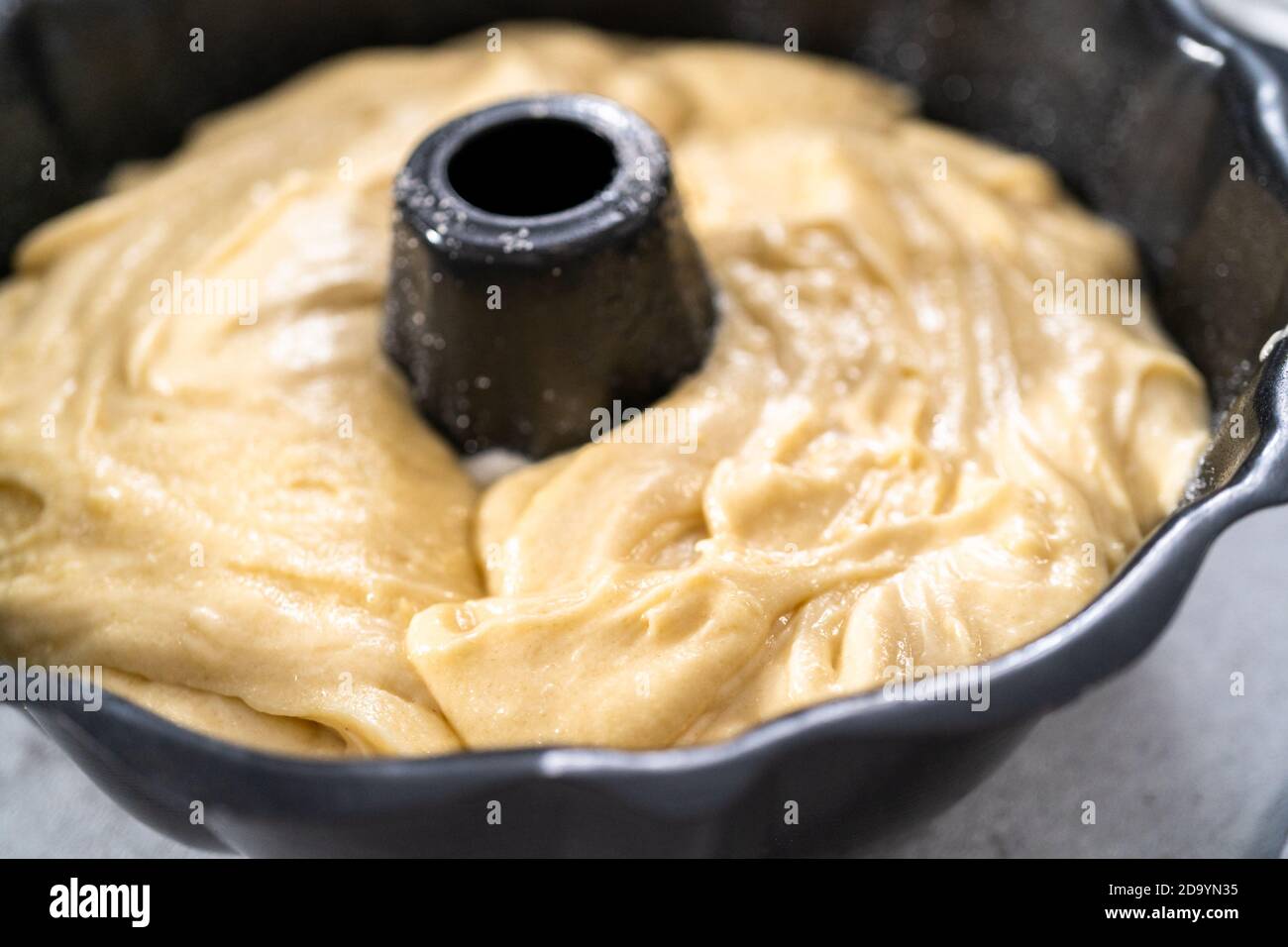 Zitronenpfaumteig in einer gebrannten Backform, fertig zum Backen. Stockfoto