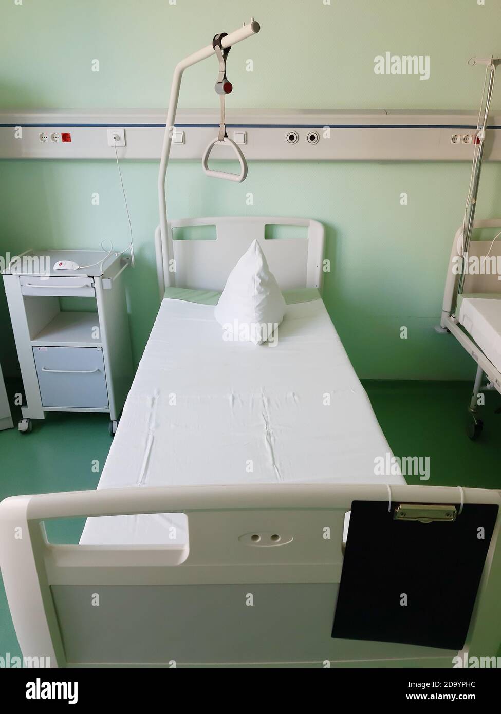 Ein Bett mit sauberer Bettwäsche im Krankenhauszimmer Stockfoto