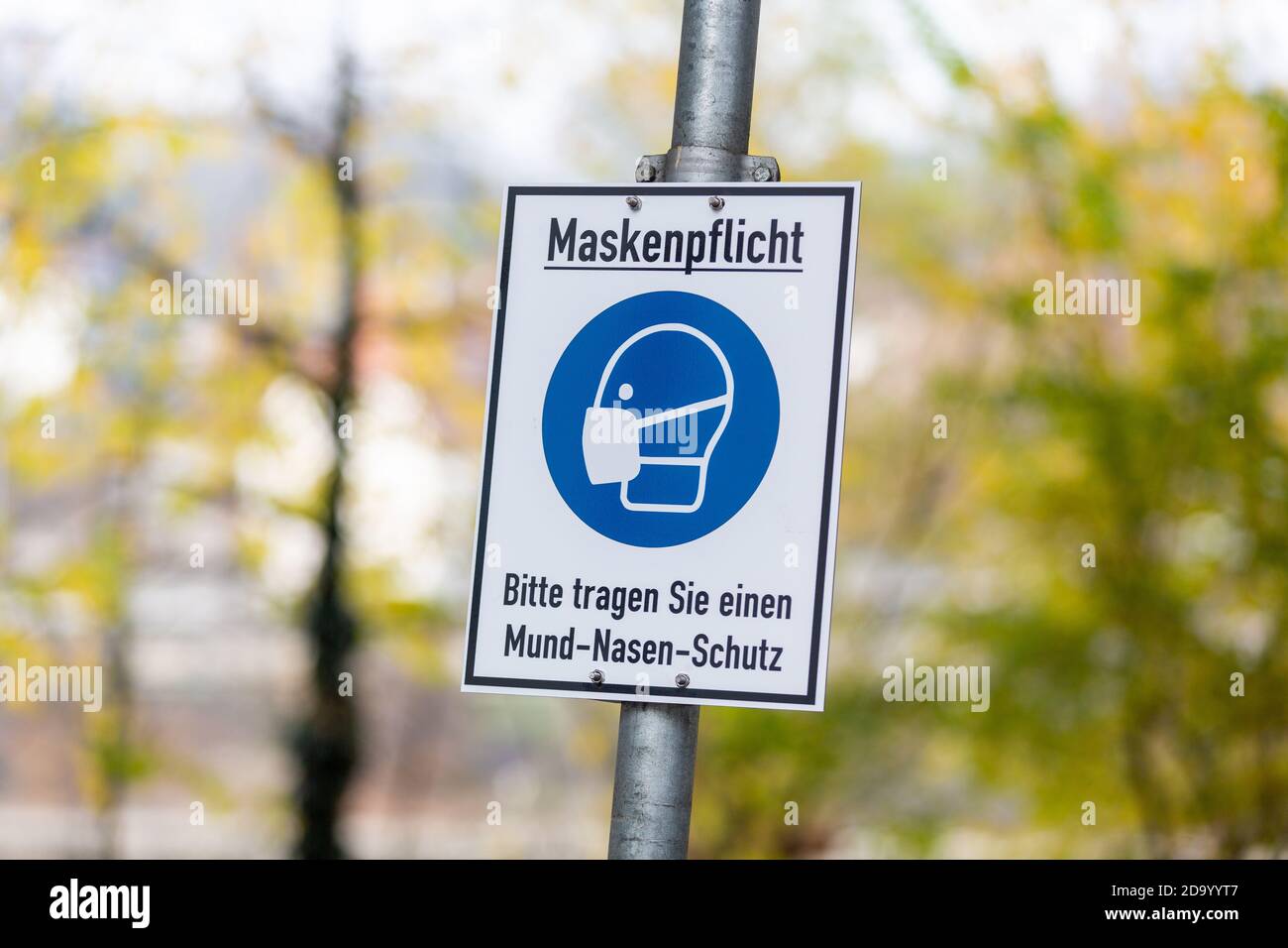 Infosign in einer deutschen Stadt mit deutschem Text. Maskenpflicht, bitte tragen Sie einen Mund-Nasen-Schutz. Maske obligatorisch, bitte Mund und Nase prot tragen Stockfoto