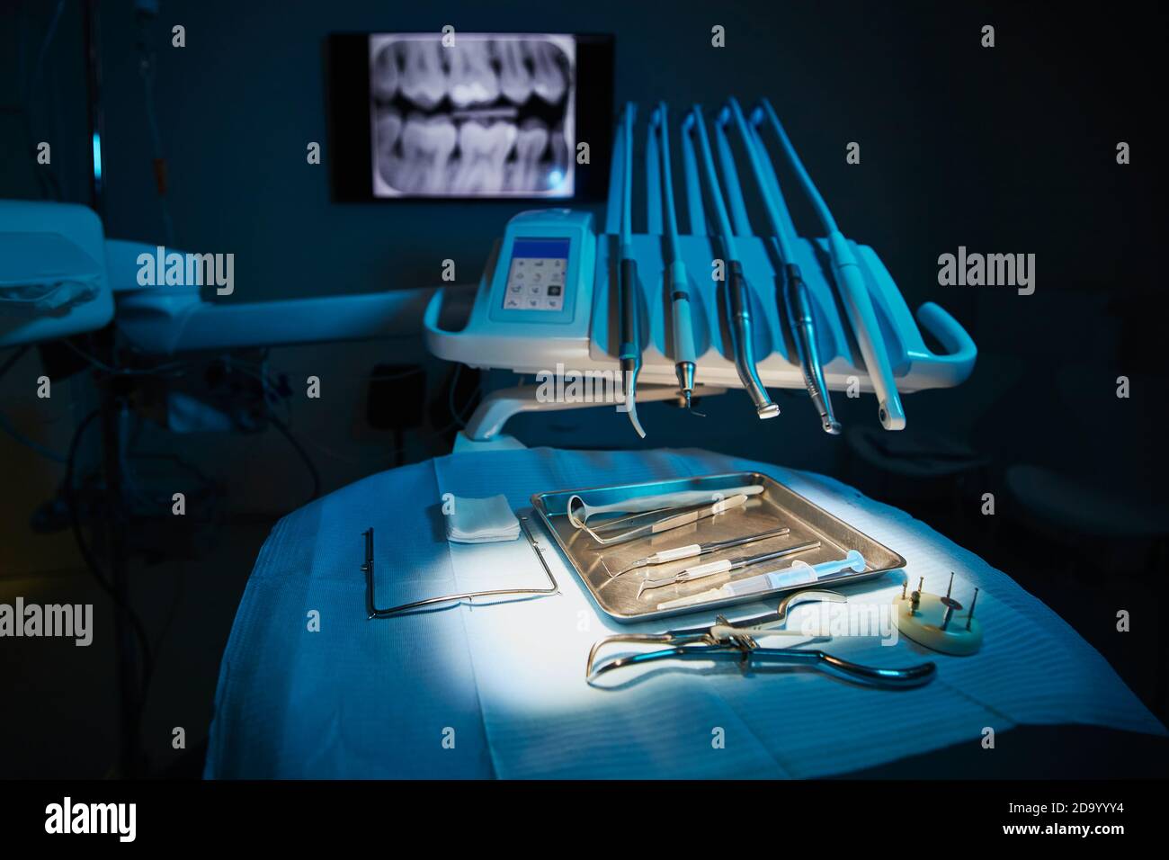 Moderne Zahnchirurgie. Medizinische Werkzeuge auf Tablett gegen Röntgenaufnahme der Zähne in der Zahnarztpraxis. Stockfoto Moderne Zahnchirurgie. Medizinische Werkzeuge auf Tablett gegen Röntgenaufnahme der Zähne in der Zahnarztpraxis. Stockfoto