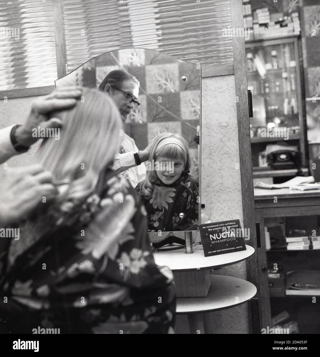 1960s, historisch, ein junges Mädchen in einem professionellen Friseursalon, das einen Haarschnitt von einem männlichen Friseur, London, England, Großbritannien, erhält. Stockfoto