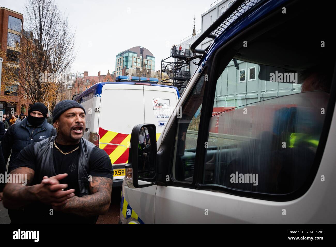 Manchester, Großbritannien. November 2020. Ein Protestler kommt bei einem Anti-Lockdown-marsch an einem Polizeiwagen vorbei. Kredit: Andy Barton/Alamy Live Nachrichten Stockfoto