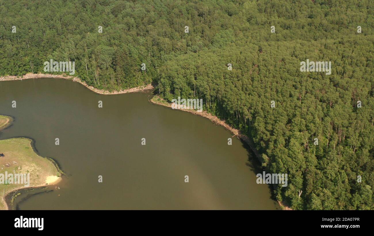 Fluss und Wald, aufgenommen von einem Quadcopter. Blick von oben auf einen dünnen Fluss und Felder um ihn herum Stockfoto