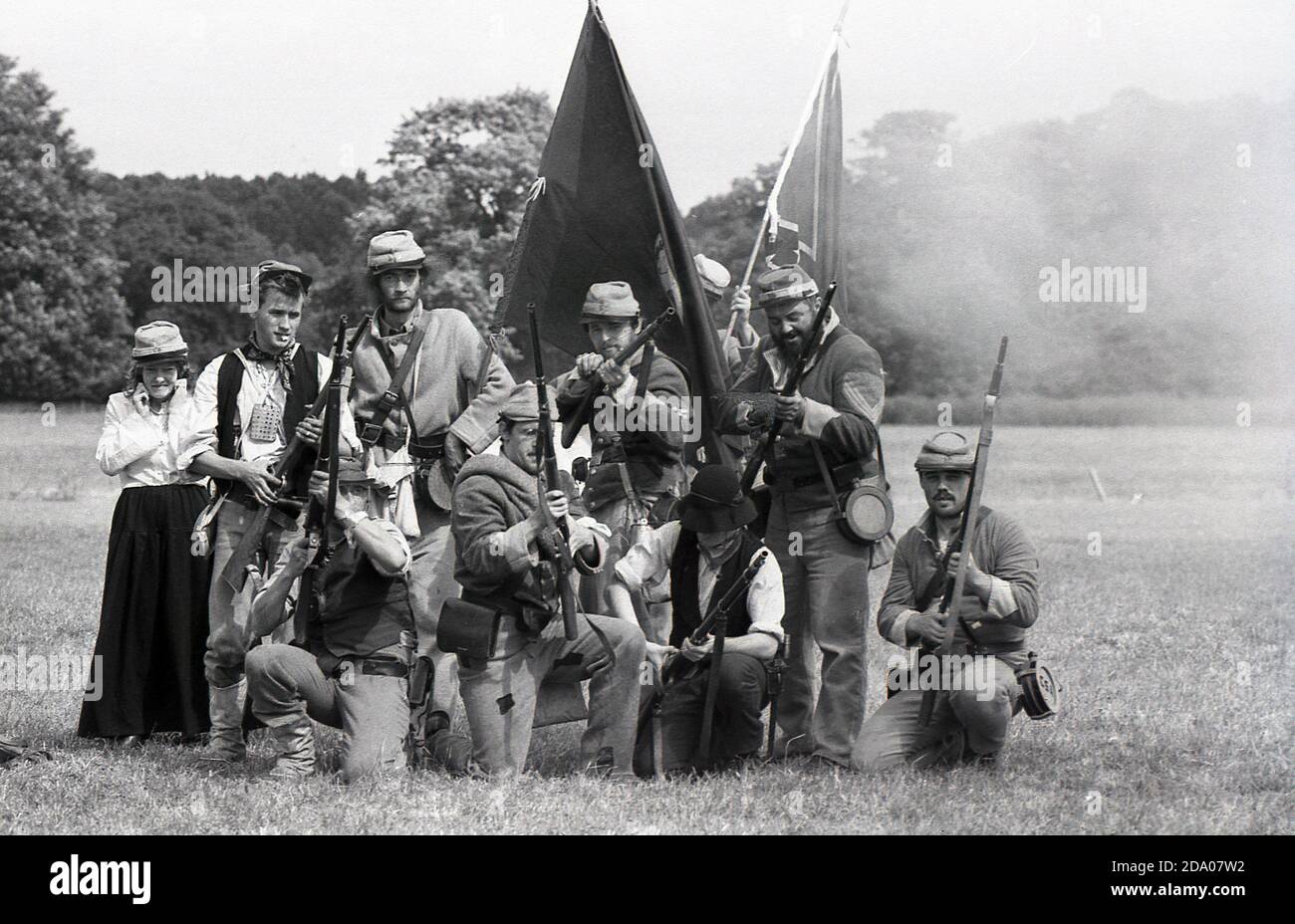 1980s, historisch, draußen auf einem Feld, Geschichtsliebhaber in Kostümen, die an einer amerikanischen Nachstellung des Bürgerkrieges teilnehmen, verkleidet als Soldaten in Armeeuniformen, mit alten Gewehren und Fahnen, England, Großbritannien. Stockfoto