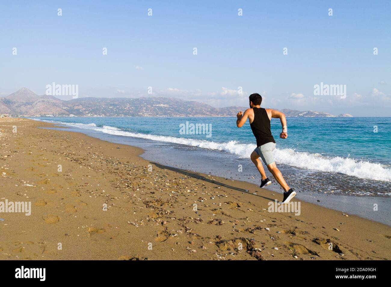 Läufer sprinten zum Erfolg Laufen auf nassem Sand am Strand. Männlicher Athlet Sprintertraining für Wettkampfschnellsprintung Lauf auf nassem Sand bei t Stockfoto