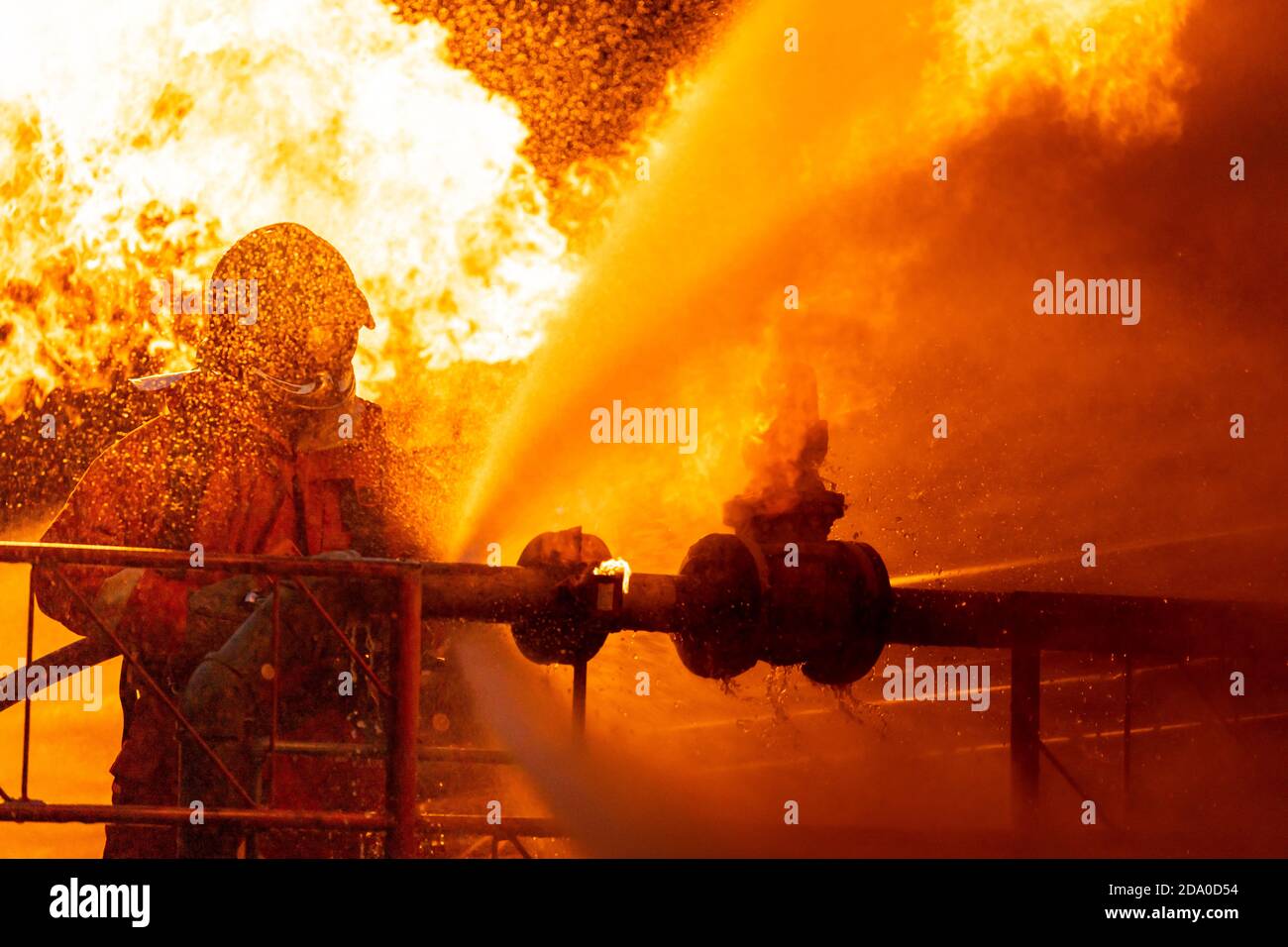 Feuerwehrmann mit Wasser Nebel Art Feuerlöscher zur Bekämpfung mit der Feuerflamme von Ölleitung Leck und Explosion auf Ölplattform und Erdgas sta Stockfoto