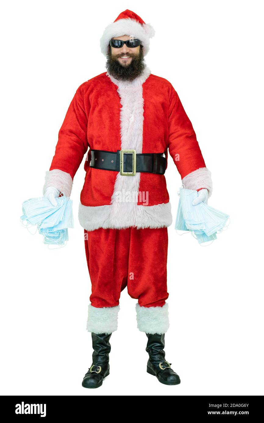 Arabisch Santa mit schwarzem Bart trägt eine covid medizinische Maske, hält Maske oder Atemschutzmasken Epidemie oder Coronavirus Schutz. Der Weihnachtsmann zeigt den Daumen nach oben Stockfoto