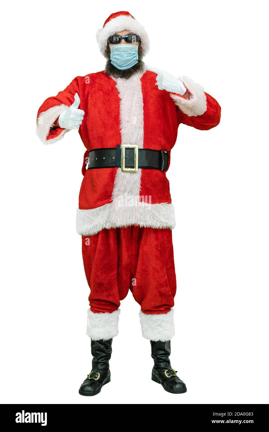 Santa tragen in einer covid medizinische Maske, wirft Daumen Zeigefinger nach oben. Weihnachten steht bevor Stockfoto