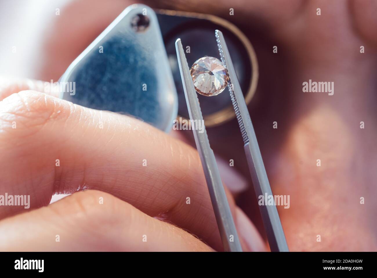 Juwelier schaut durch eine Lupe auf Edelstein Stockfoto