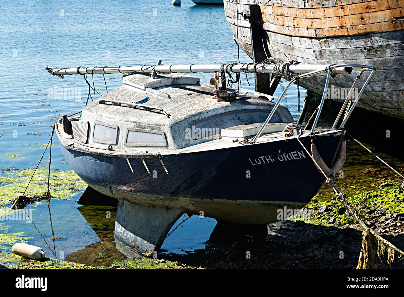 Vernachlässigt kleine Segelyacht in der Notwendigkeit der Reinigung auf dem Vorland bei Dell Quay, Chichester Harbour, West Sussex, England, Großbritannien Stockfoto