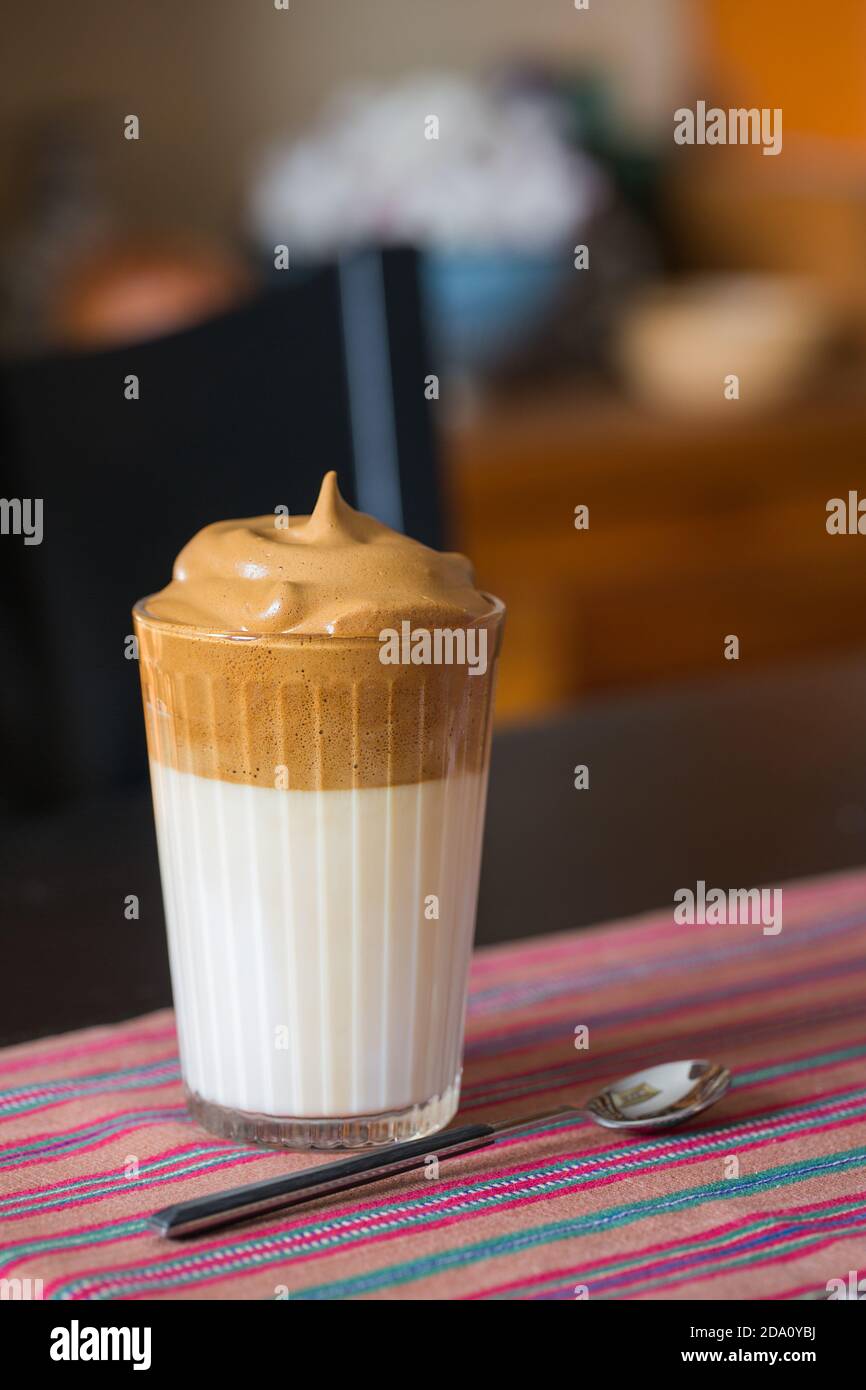Ein Glas aromatischen kalten Dalgona Kaffee serviert auf dem Tisch in Dunkles Zimmer Stockfoto