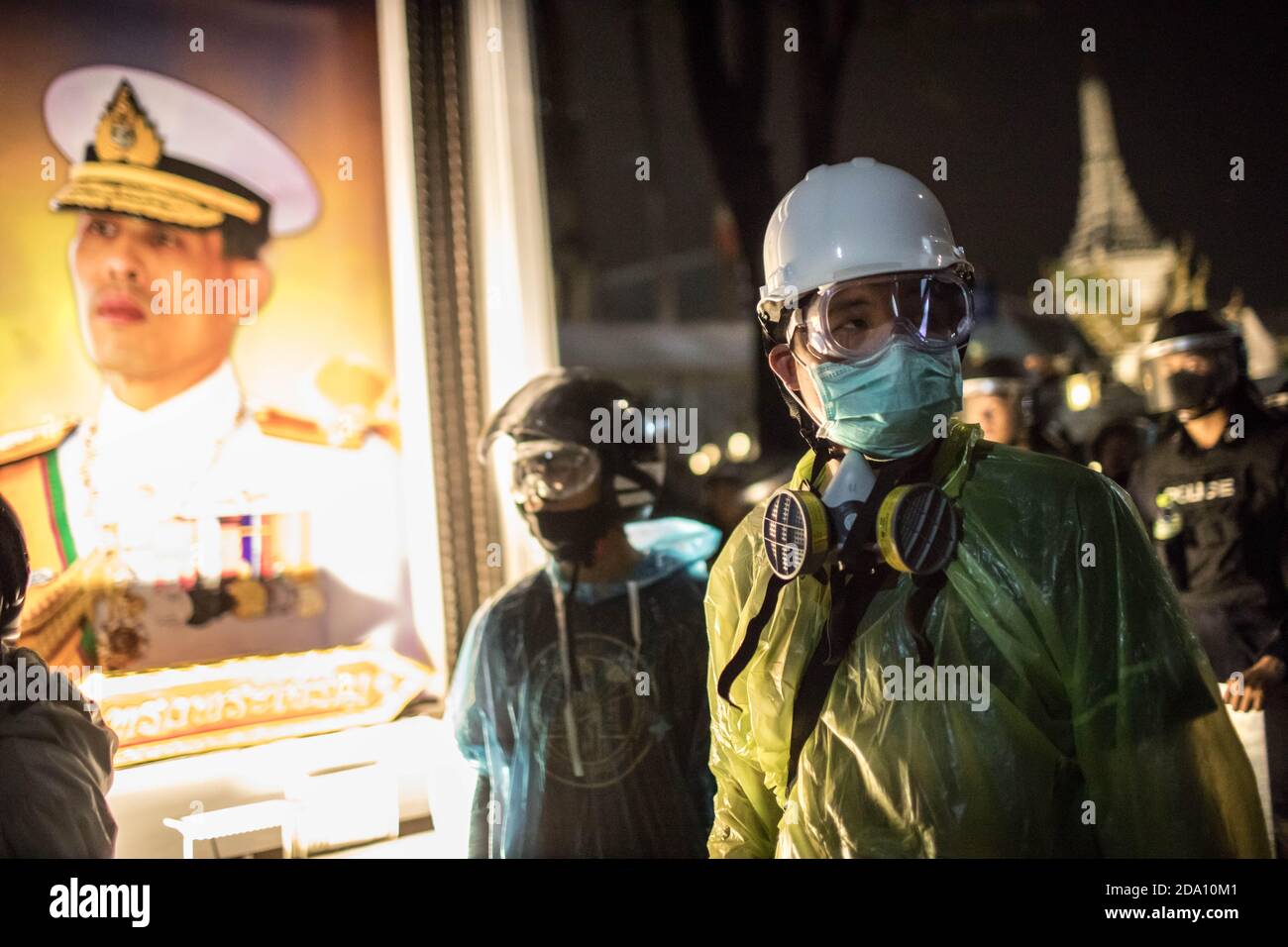 Bangkok, Thailand. November 2020. Prodemokratische Demonstranten, die neben einem Porträt des thailändischen Königs Maha Vajiralongkorn (Rama X) während einer regierungsfeindlichen Demonstration in der thailändischen Hauptstadt gesehen wurden. Prodemokratische Demonstranten gingen auf die Straßen am Democracy Monument, um in Richtung des Großen Palastes zu marschieren, um dem thailändischen König Maha Vajiralongkorn (Rama X) einen Brief zu überbringen. Die Demonstranten wurden von der thailändischen Polizei getroffen, die Stadtbusse und Stacheldraht benutzte, um die Straße zu blockieren. Und Wasserkanonen, um die Menge in Sanam Luang vor dem Großen Palast zu zerstreuen. Kredit: SOPA Images Limited/Alamy Live Nachrichten Stockfoto