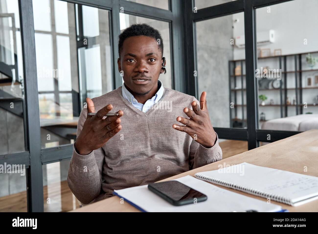 Afrikanischer Geschäftsmann mit Headset im Gespräch mit Kamera, Web-Cam-Ansicht. Stockfoto