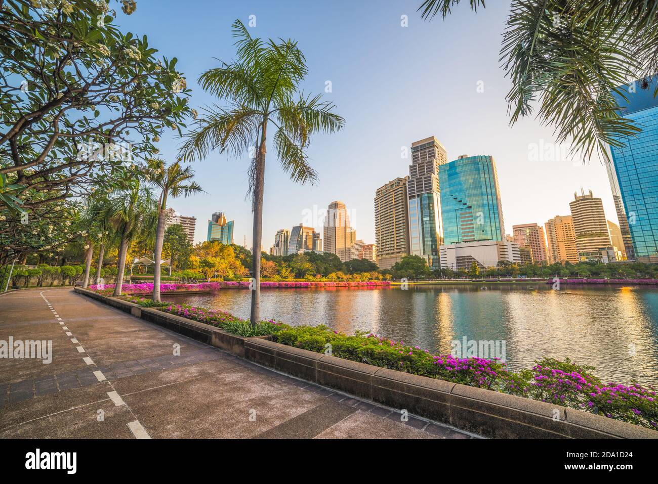 Schöner Laufweg im Stadtpark. Wundervolle Aussicht auf den Benjakiti Park bei Sonnenaufgang. Schöne Morgenszene des öffentlichen Parks in Bangkok, Thailand, Asien. Stockfoto