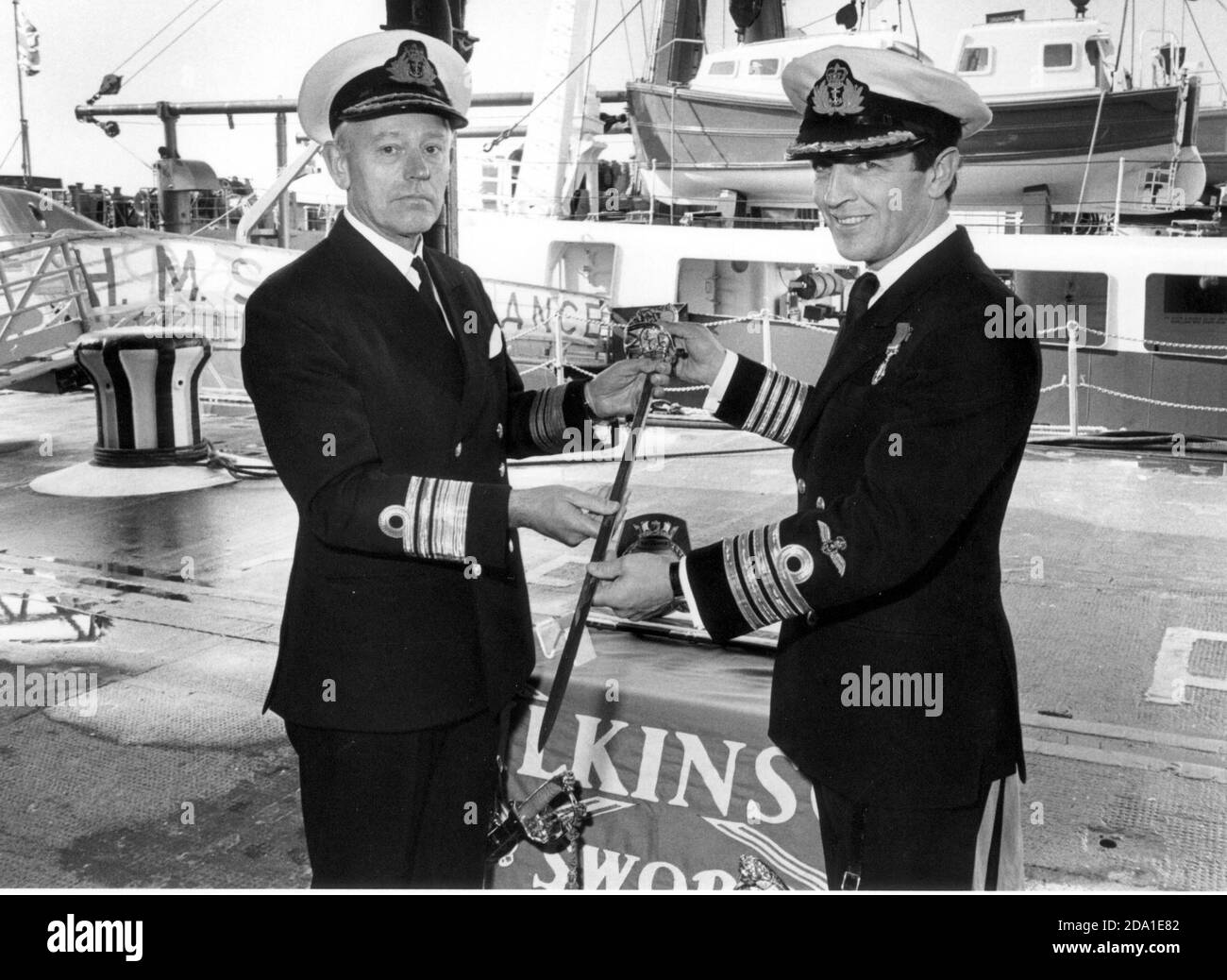 PRÄSENTATION DES WILKINSON-SCHWERTES DES FRIEDENS. CAPT. C.L MACGREGOR (RECHTS) ERHÄLT DAS SCHWERT IM AUFTRAG VON HMS ENDURANCE VON VIZEADMIRAL D,R, REFFELL BEI DER WIEDERWEIHUNG DES SCHIFFES IN PORTSMOUTH. 1983 Stockfoto