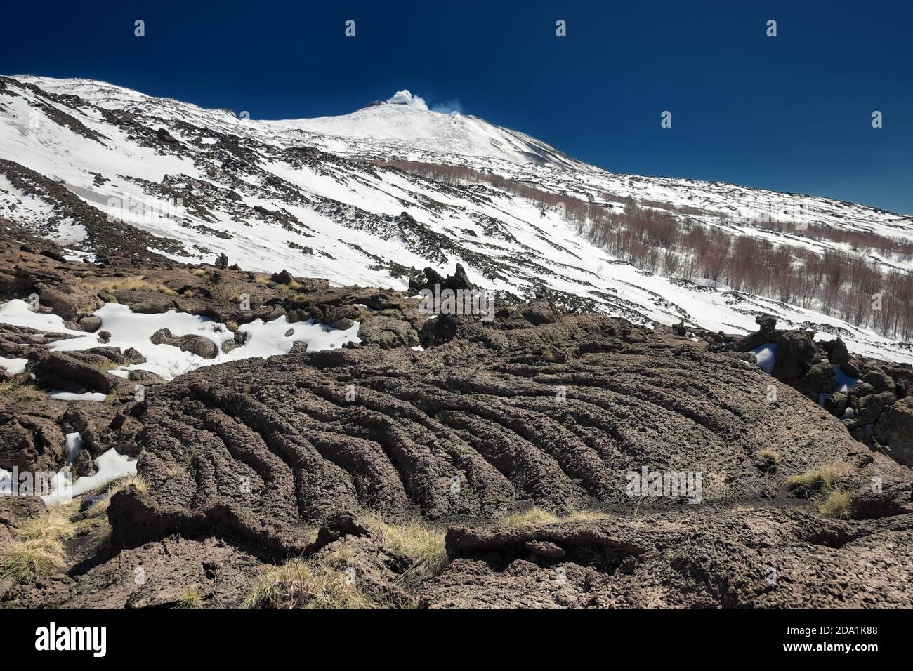Gekühlter Lavastrom-Oberfläche, im Hintergrund Winter Ätna Vulkan, Sizilien Stockfoto