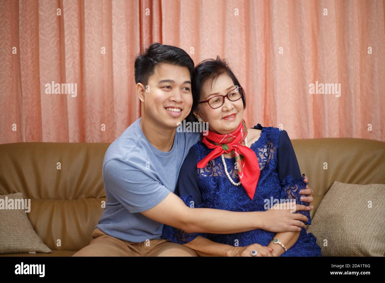 Erwachsener Sohn kommt nach Hause und umarmt Mutter auf die Mütter Tag Stockfoto