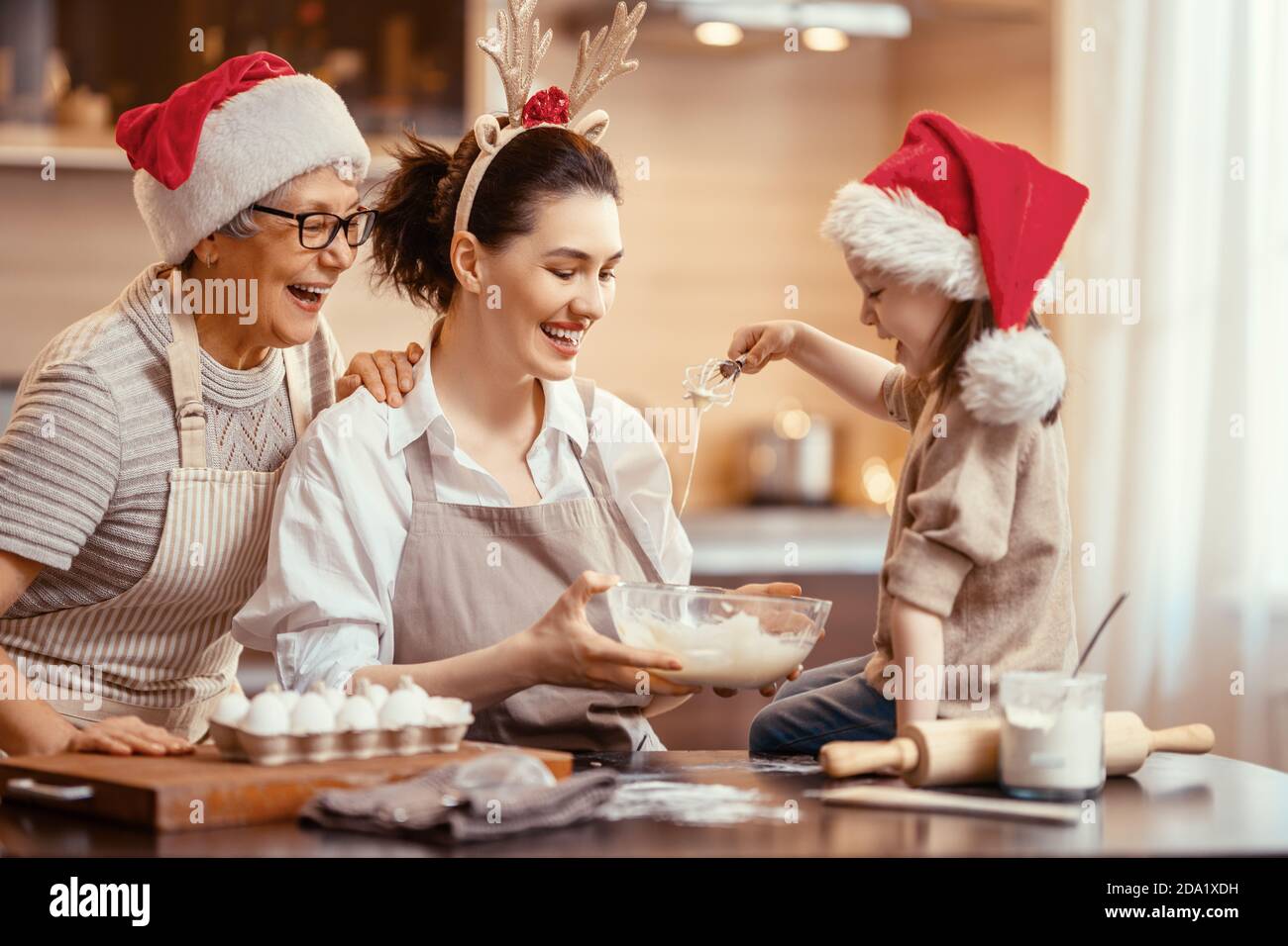 Frohe Weihnachten und frohe Feiertage. Familienzubereitung Urlaub Essen. Oma, Mutter und Tochter kochen Kekse. Stockfoto