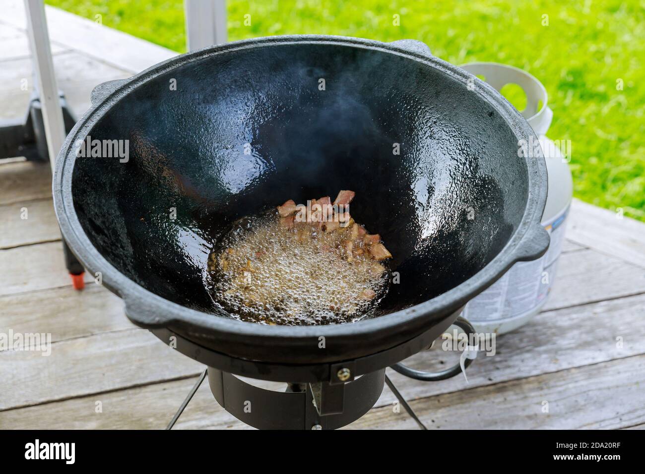 Ein großer Kessel mit gebratenem Speck für die Herstellung von Pilaf. Stockfoto