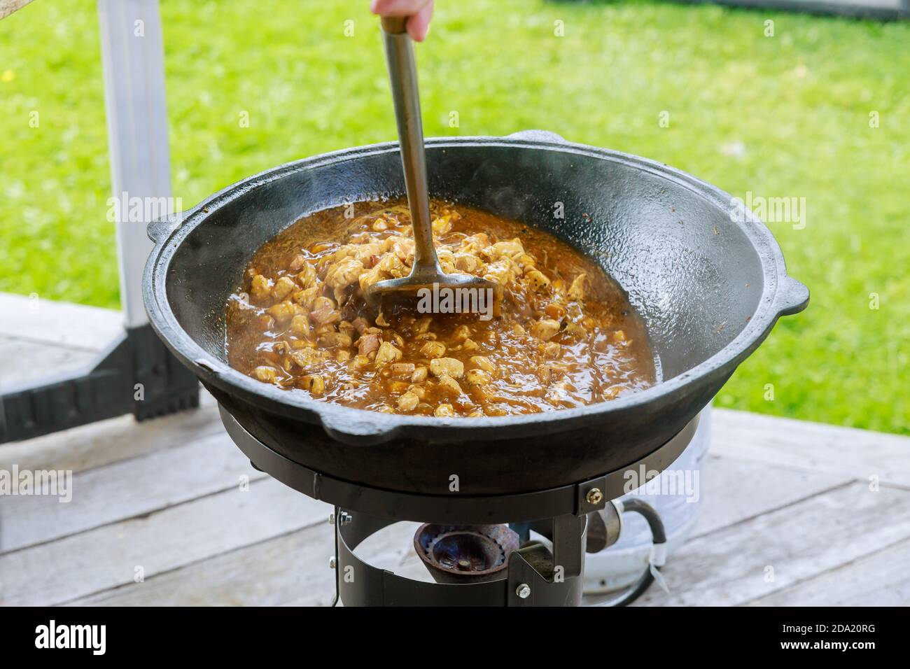 Gulasch im Kessel mit Schweinefleisch, Karotten und Gewürzen. Im Freien. Stockfoto